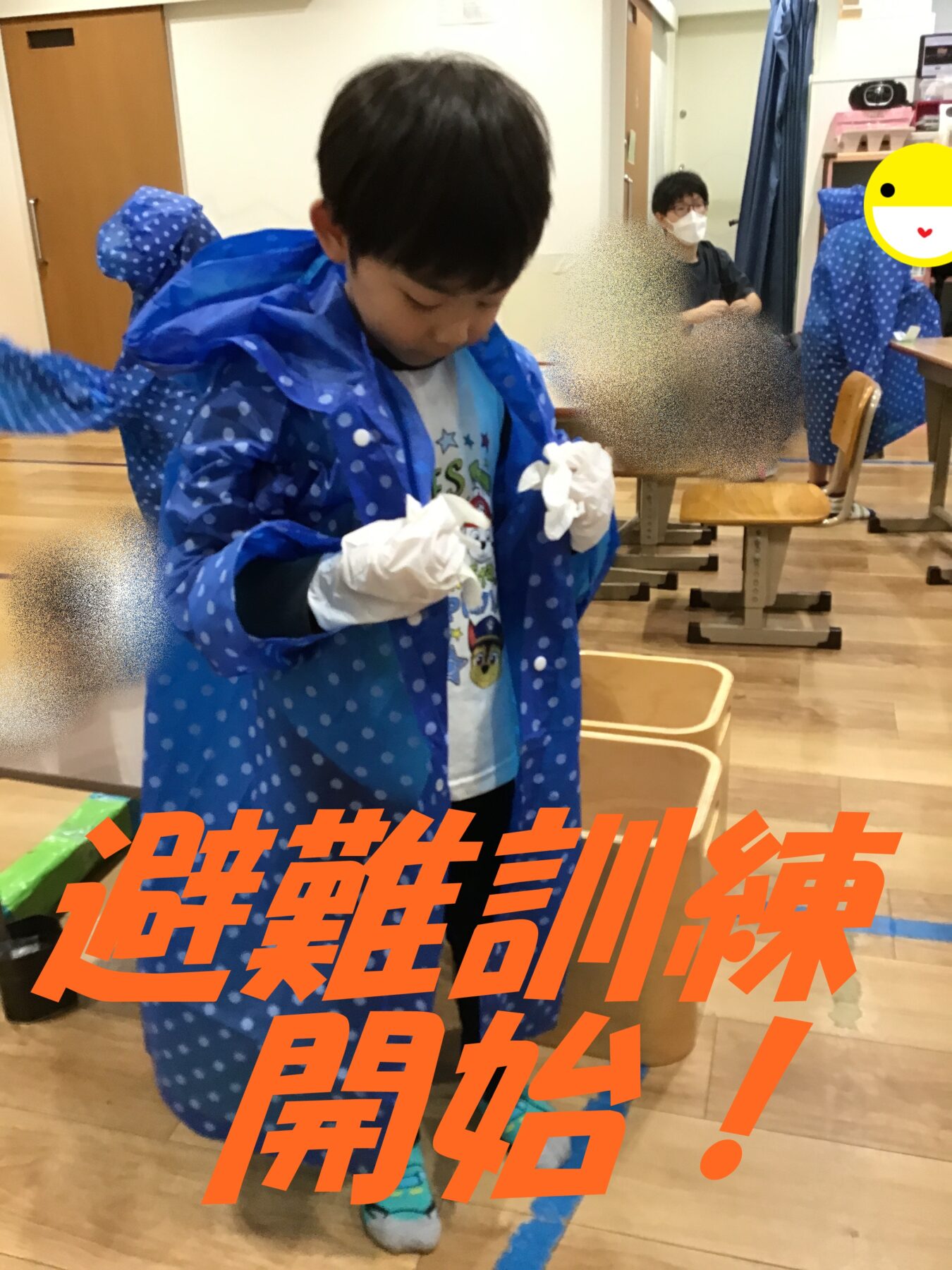 A young child in a blue polka-dot raincoat stands in a classroom during an evacuation drill; a masked adult and other students are in the background.