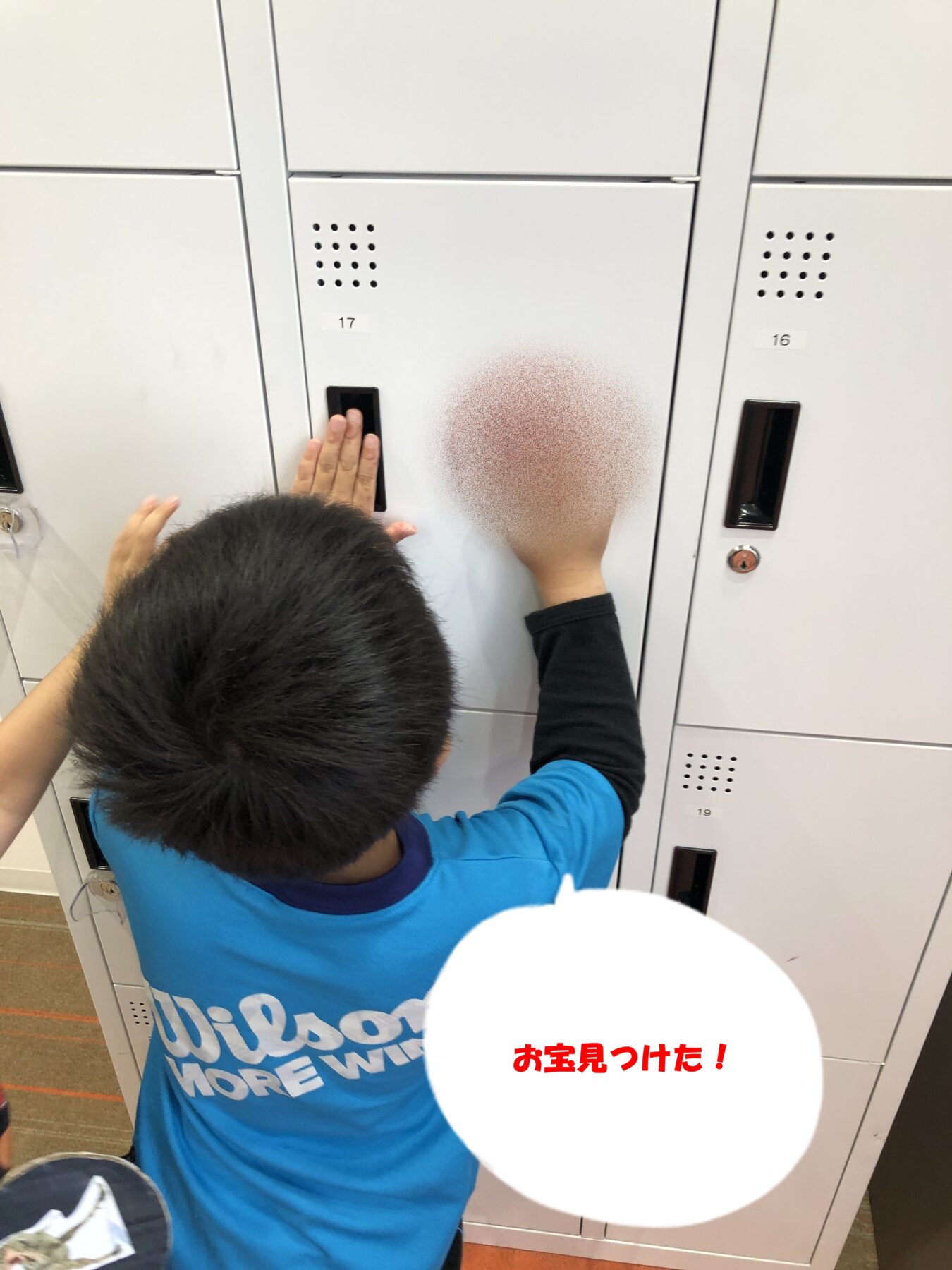 Child in a blue shirt taps a gray locker door; face is blurred and a white speech bubble reads 'お宝見つけた！' (Found treasure!).