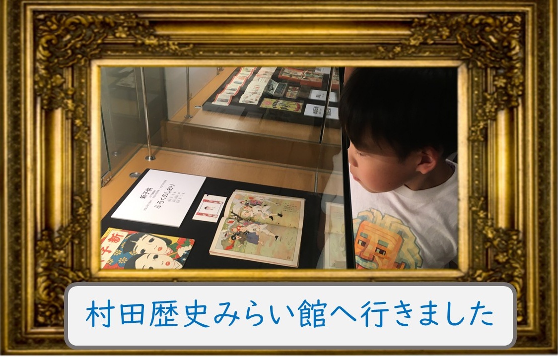 A young child looking into a glass display case at a museum, examining old books and illustrated pages; ornate gold frame surrounding the scene. A Japanese caption at the bottom reads 'I went to Murata History Mirai-kan.'