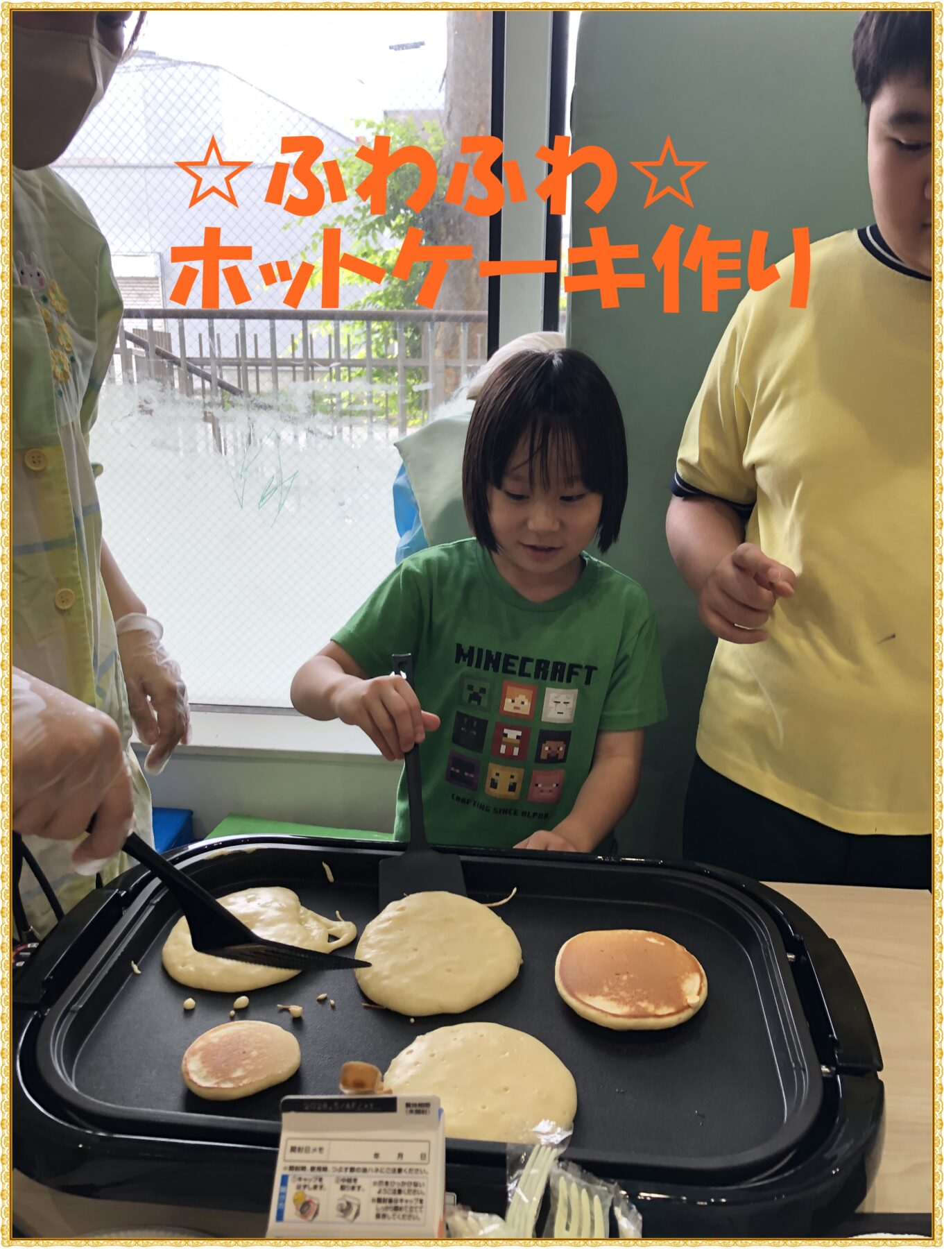 Kids cooking fluffy pancakes on a griddle, with orange Japanese text overlay reading ふわふわホットケーキ作り.