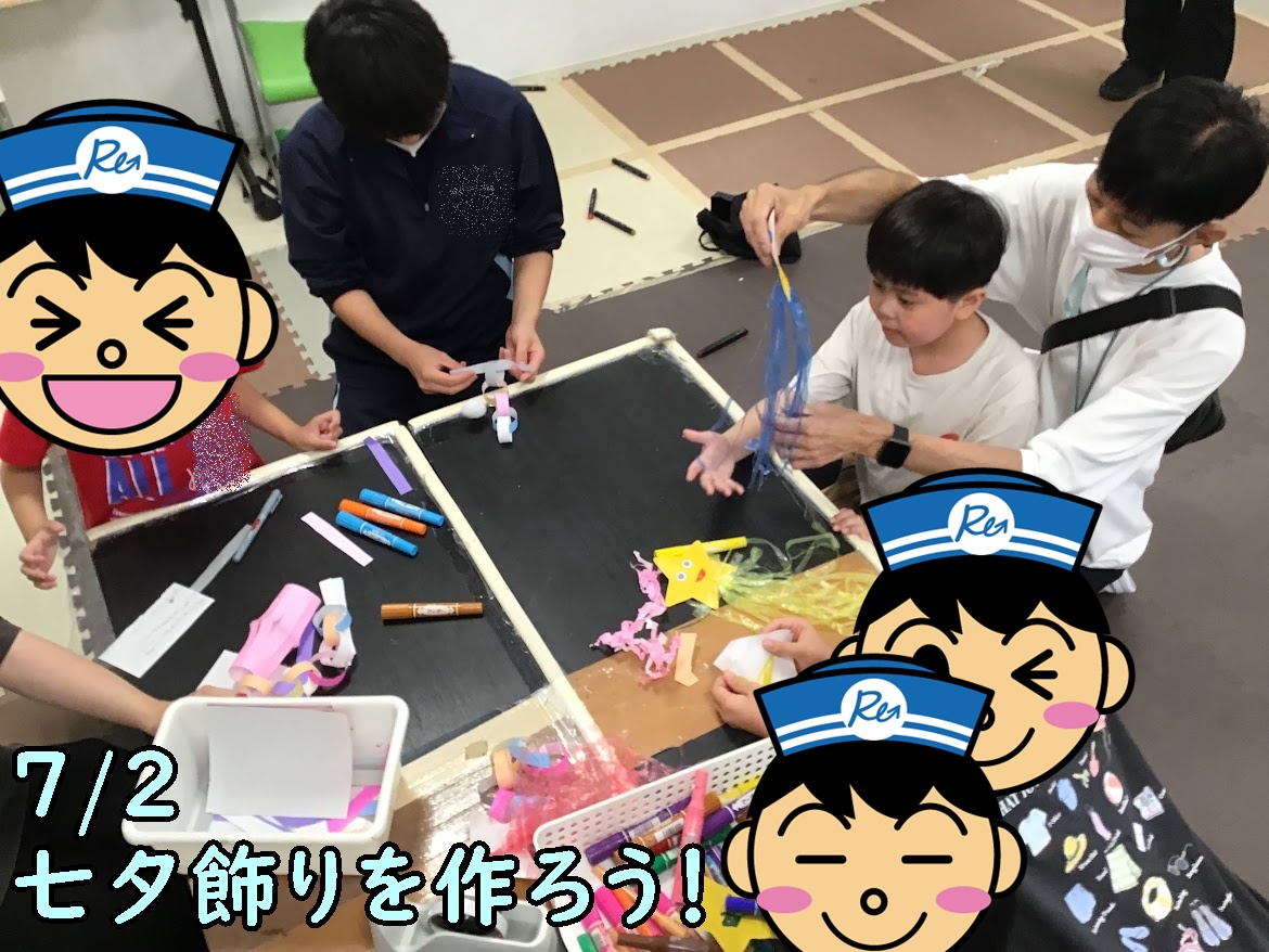 Children and an adult craft Tanabata decorations at a table with colored paper strips, markers, and scissors.