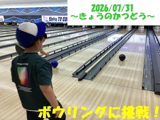 A young boy wearing a blue-and-white cap and green shirt watches a bowling ball roll down a lane in a bowling alley, with lanes receding into the distance and a banner with Japanese text overhead.