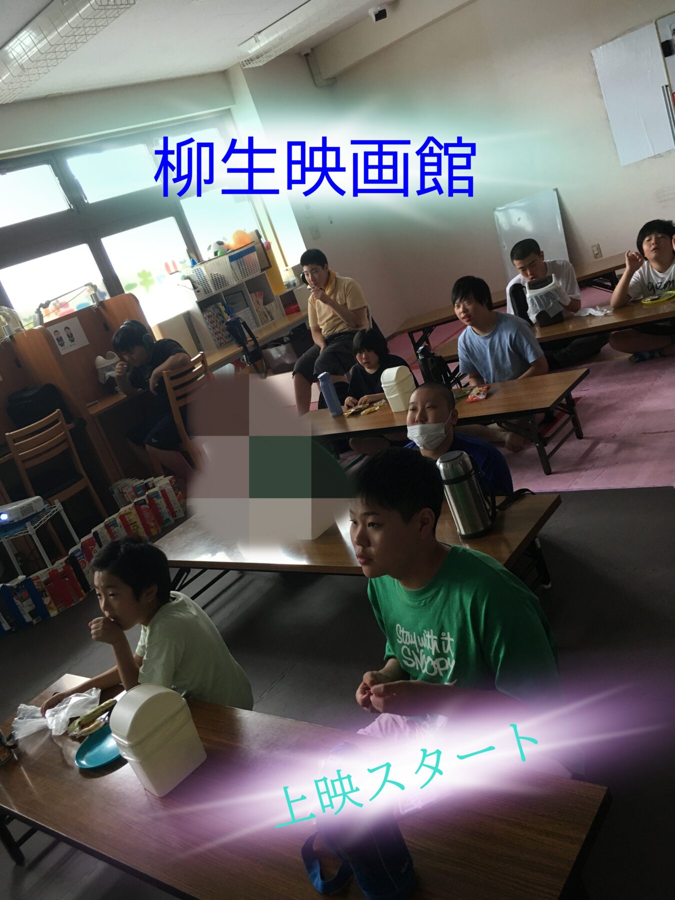 Group of kids in a classroom watching a screening, with large blue Japanese banner reading '柳生映画館' and a pink glow saying '上映スタート' overlay.