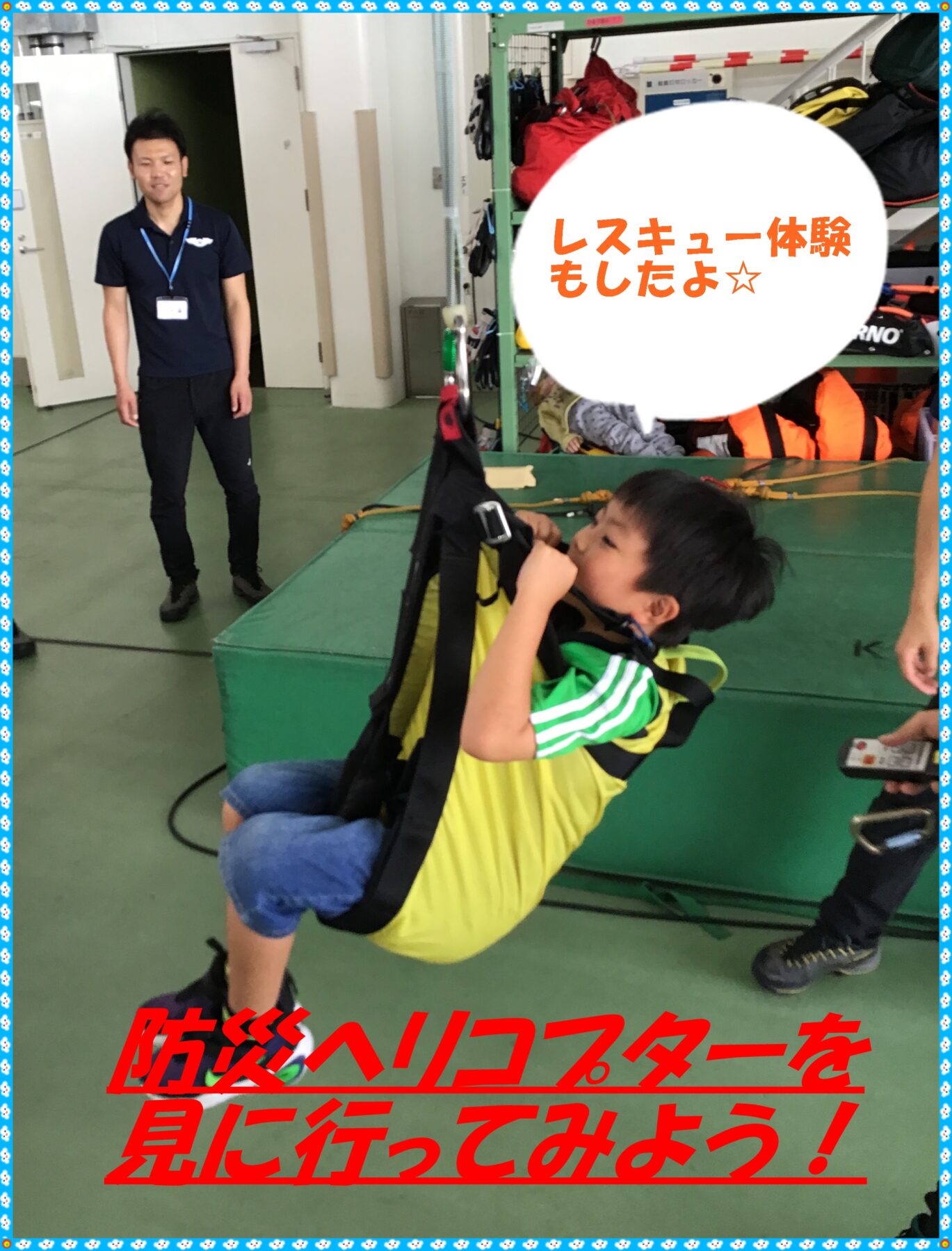 Child in a yellow safety harness sits on a green padded platform, preparing for a rescue‑training activity as a trainer watches nearby in a room filled with gear and shelves.
