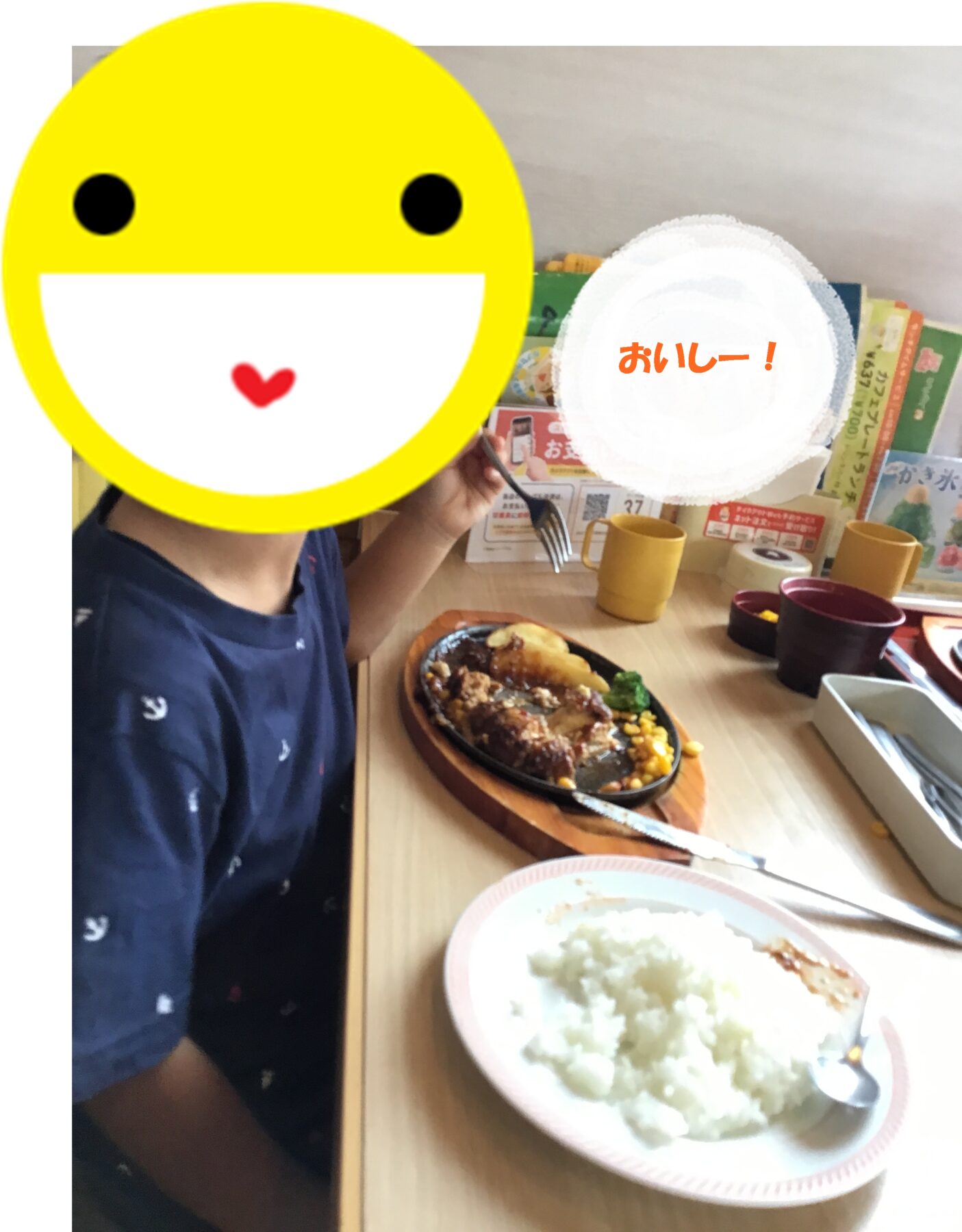 Child at a restaurant with a curry-and-rice plate and a fork, emoji overlay covering the face, Japanese text 'おいしー！' in a white circle in the background