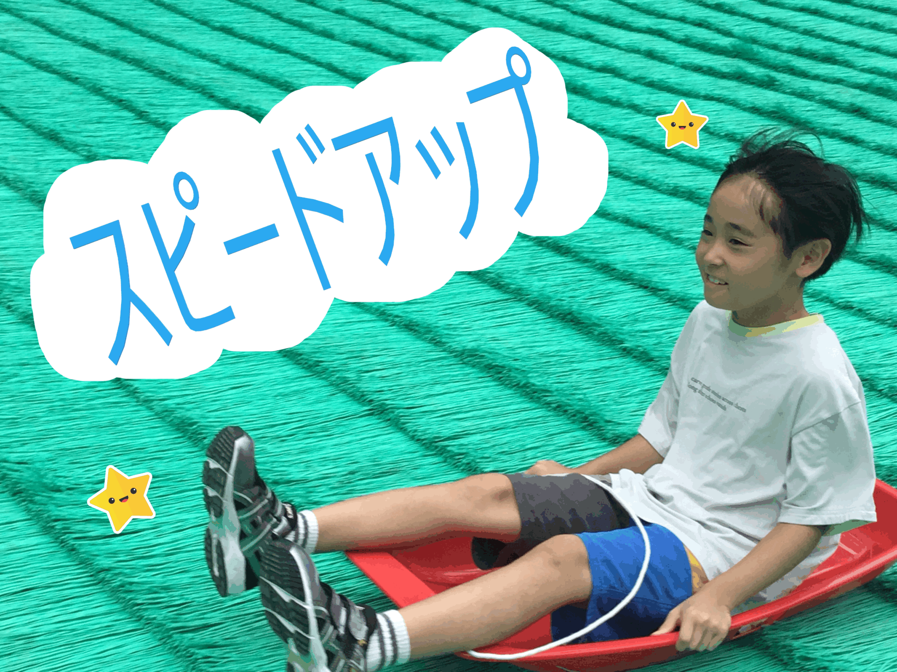 Boy smiling on a red sled, teal striped background, with a white cloud containing blue Japanese text and yellow star stickers.