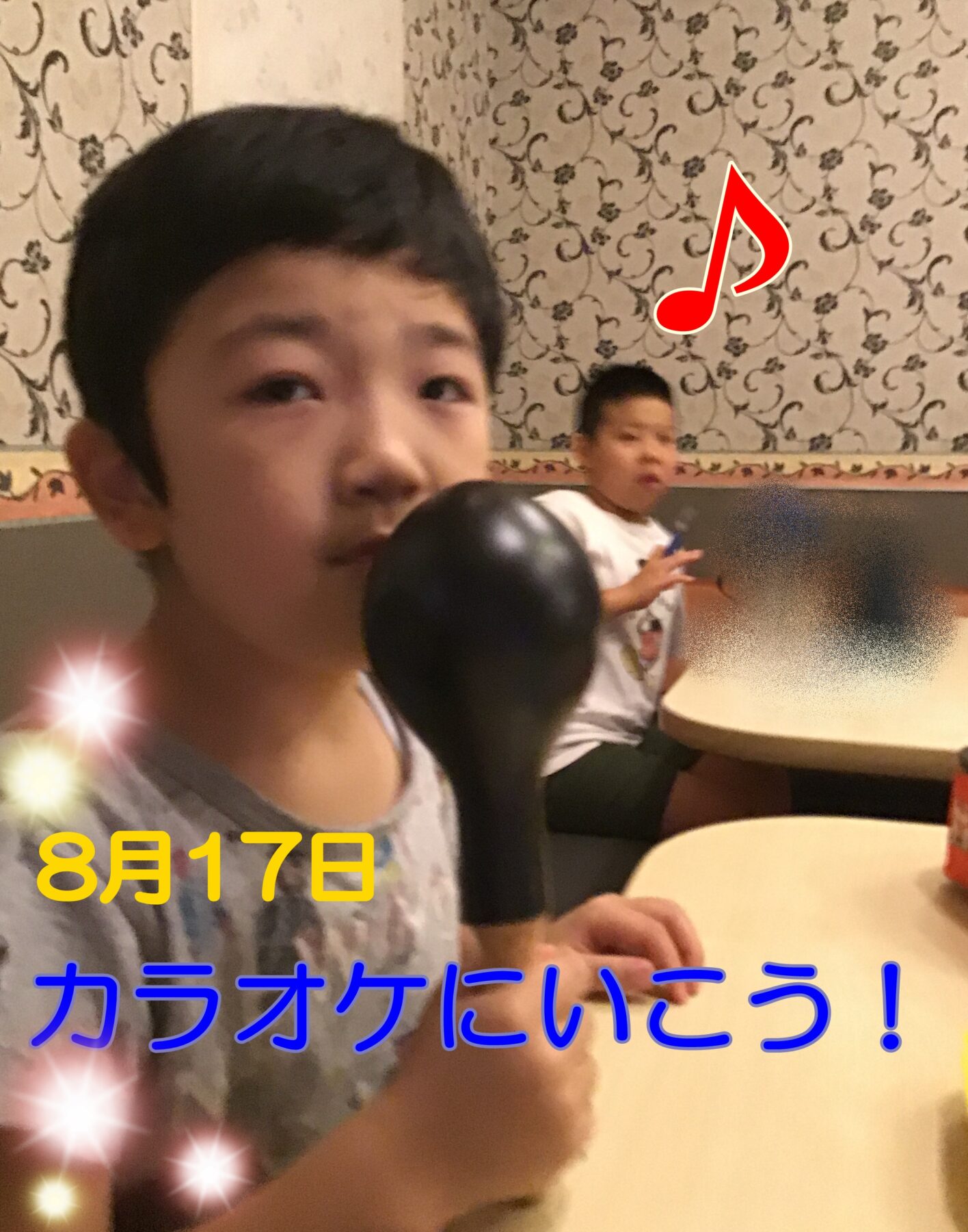 Close-up of a person in the foreground in a karaoke venue, with another person seated at a table in the background and a large red musical note overlay plus a date stamp.