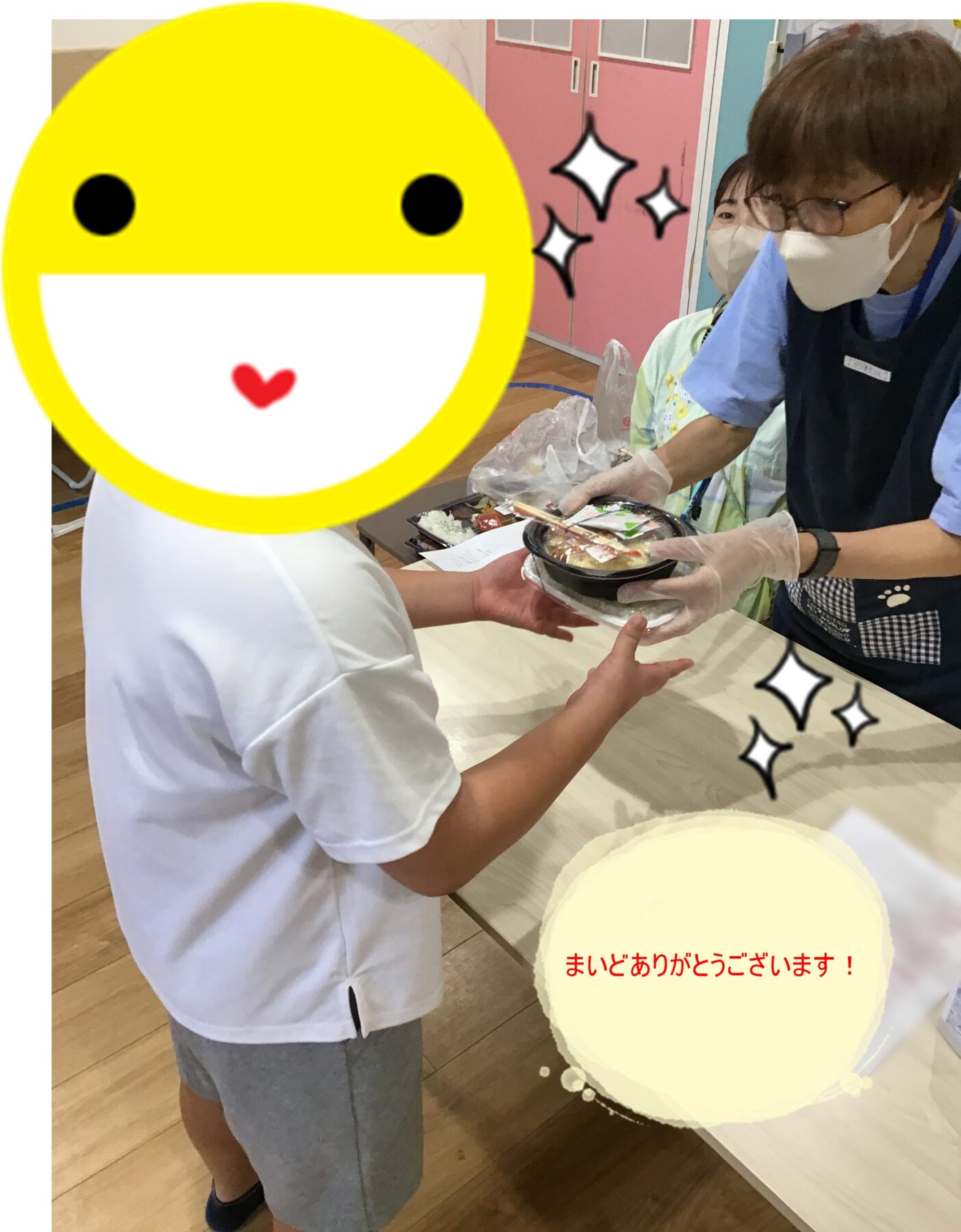 Child in white shirt hands a bowl of food to a masked, gloved volunteer; large yellow smiley overlay obscures the child's face.