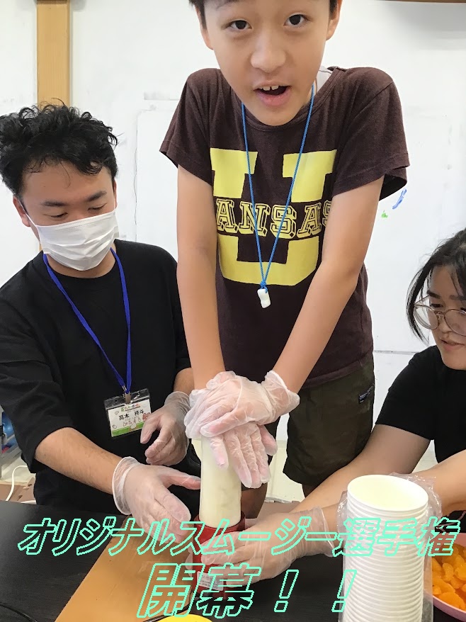 Center-stage boy wearing a brown Kansas shirt, glove-clad, stands at a table and handles a project with two adults assisting nearby; Japanese event text overlays the image.
