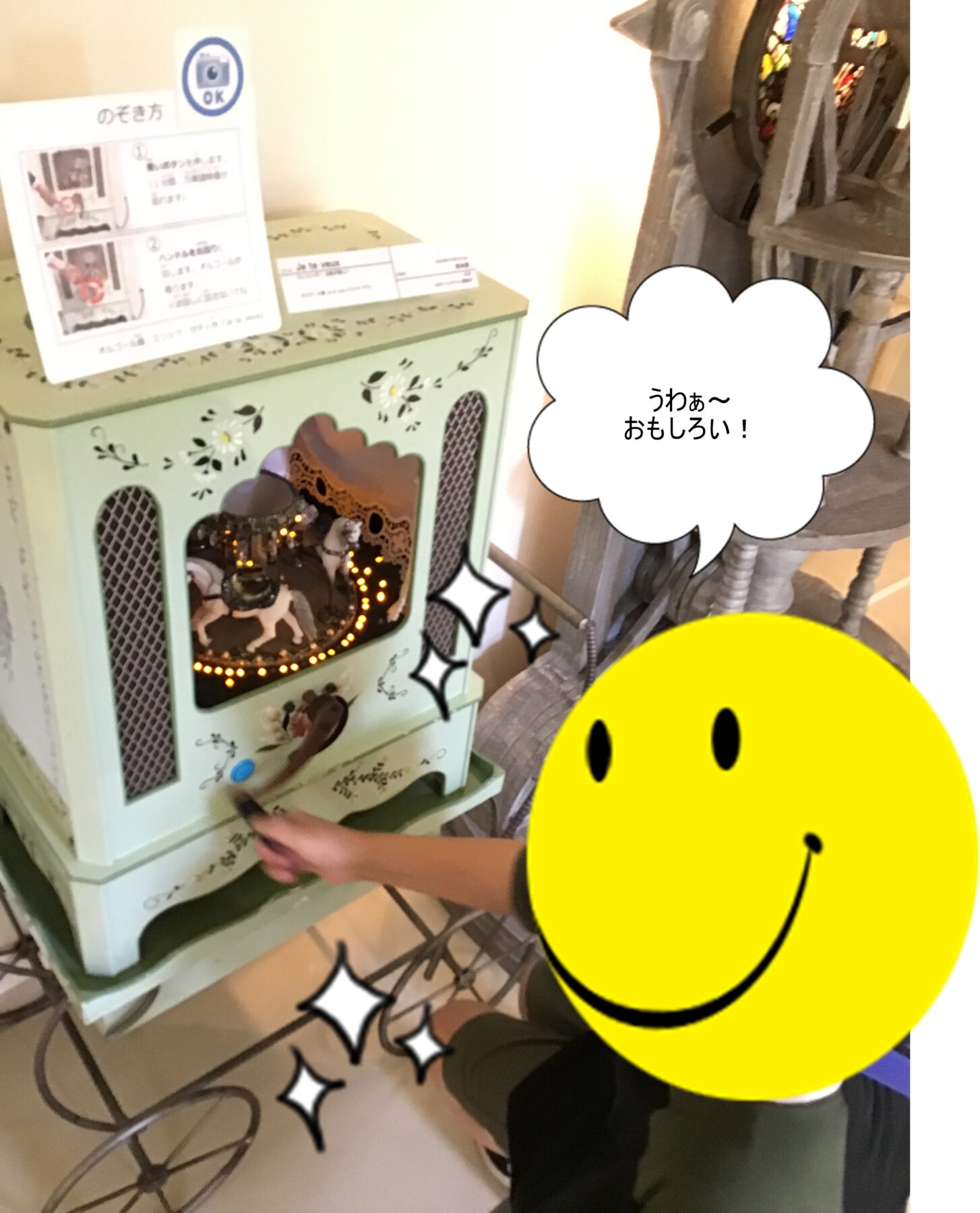 Child’s hand turning a knob on a pastel green vintage-looking decorative stove with lights inside and floral details.