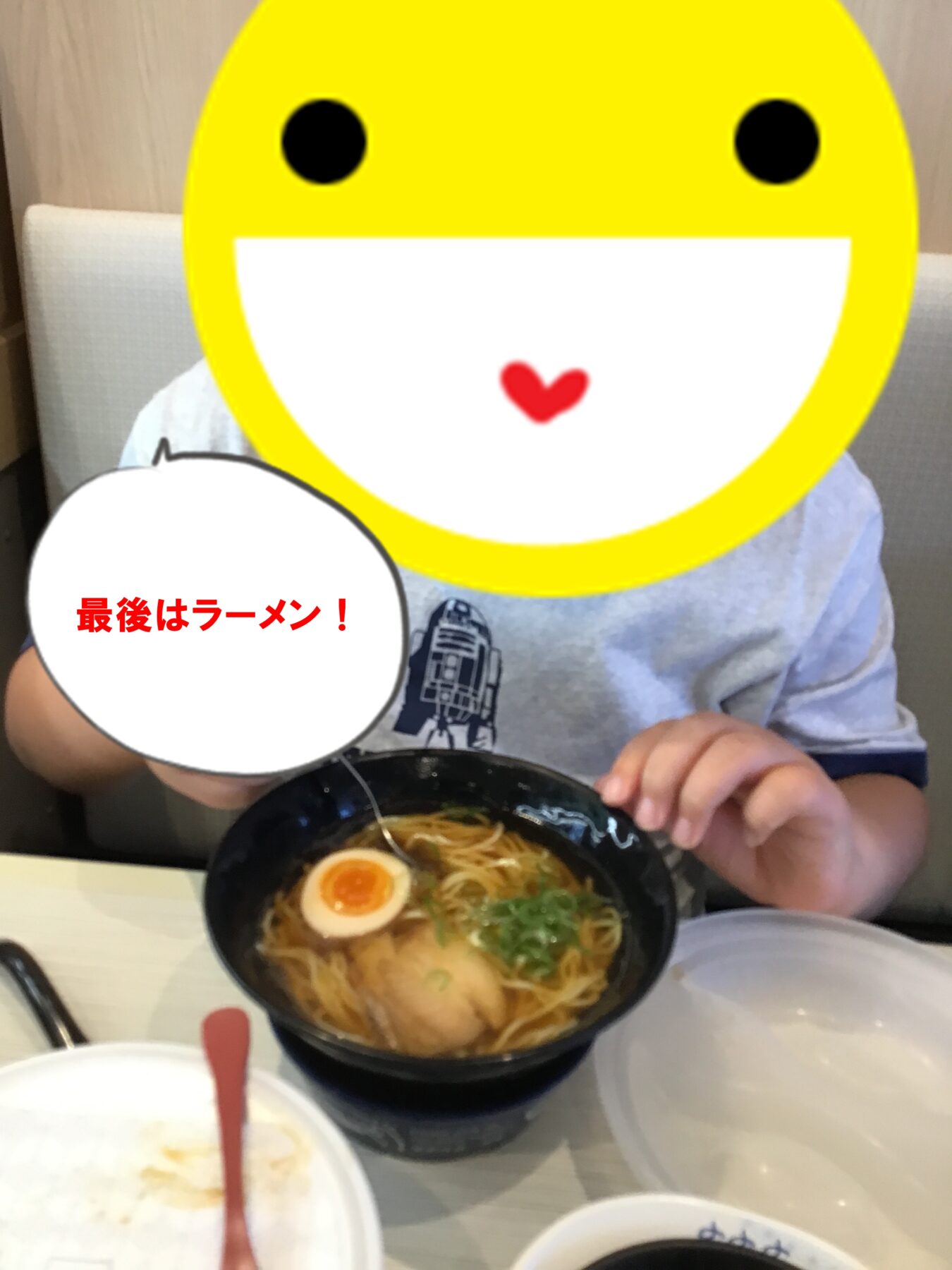 Person with a large yellow smiley face overlay eating ramen in a restaurant; a speech bubble in Japanese reads '最後はラーメン！'