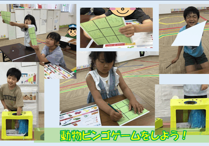 Group of children in a classroom playing animal bingo, holding green bingo cards and writing.