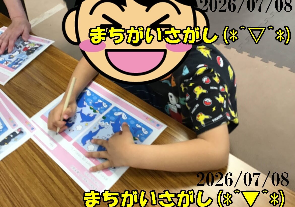 Child coloring blue worksheets at a wooden table; face is covered by a large laughing emoji, pencil in hand; date 2026/07/08 overlaid.