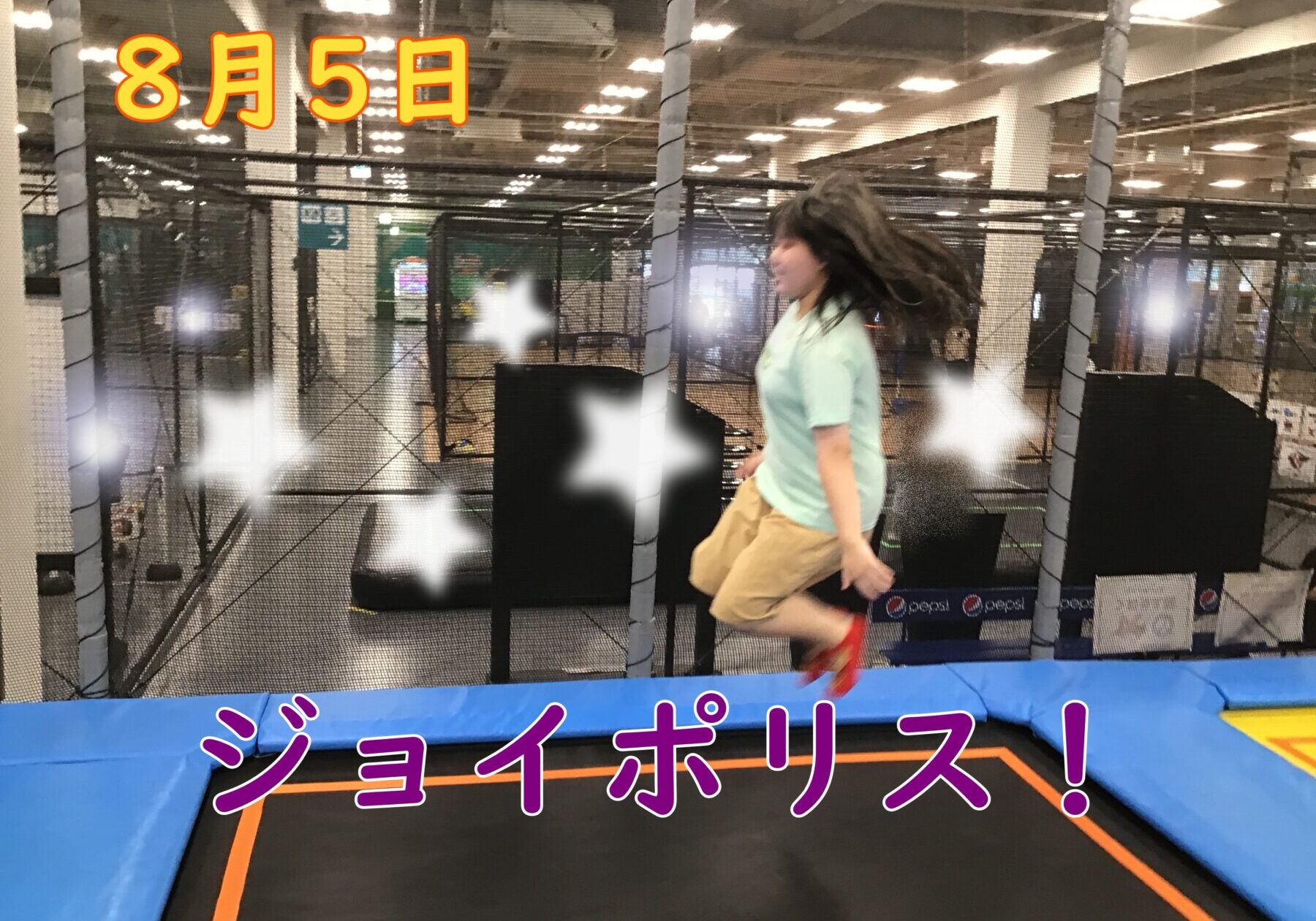Person bouncing on a trampoline inside an indoor park, with safety nets and bright blue padded edges; large purple Japanese text 'ジョイポリス!' across the bottom.